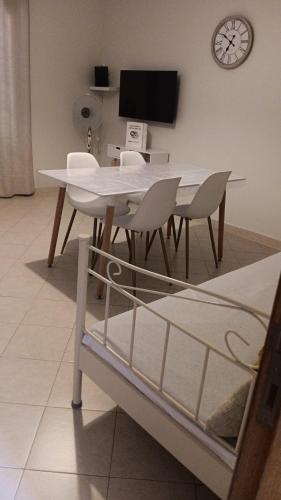 a white table and chairs in a room with a tv at Vivenda para férias (Algarve) in Manta Rota