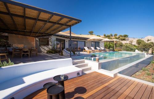 a house with a swimming pool and a wooden deck at Cloud Nine Villa in Évyiros