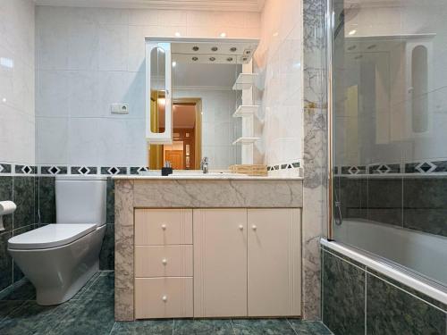 a bathroom with a toilet and a sink and a tub at Los Amantes de Teruel viven aquí in Teruel