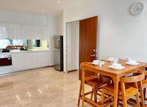 a kitchen and dining room with a wooden table and chairs at Sky Suites KLCC by TD Luxe Global in Kuala Lumpur
