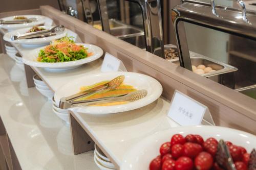 a buffet with plates of food on a counter at Shangge Boya Hotel in Shangri-La