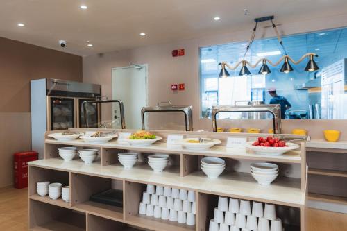 a counter with bowls and plates of food in a kitchen at Shangge Boya Hotel in Shangri-La