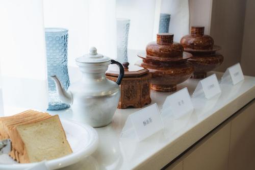 a counter with a plate of bread and vases on it at Shangge Boya Hotel in Shangri-La