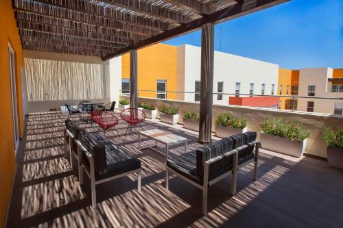a patio with a table and chairs on a balcony at City Express Plus by Marriott Cabo San Lucas in Cabo San Lucas