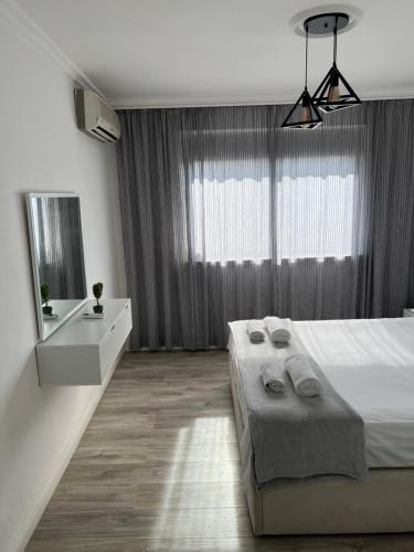 a bedroom with a large bed and a large window at Fila Apartments in Tirana