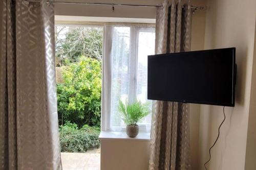 a flat screen tv in a room with a window at Apartment - Sleeps 2 - Parking - Wi-Fi in Reading