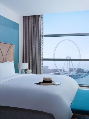 a bedroom with a large bed with a ferris wheel in the background at Sofitel Dubai Jumeirah Beach in Dubai