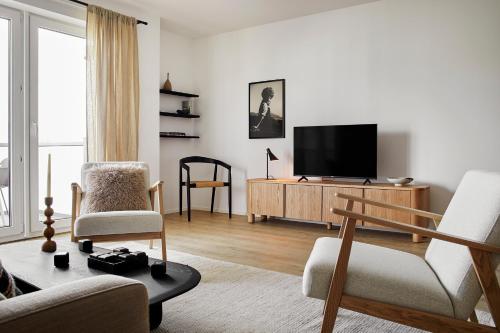 Una sala de estar con un televisor de pantalla plana sobre un mueble de madera. en MATT - Apartments ' Design-Apartment mit Balkon, en Offenburg