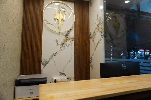 a large clock on a wall with a desk at Stazy Suites Kammanahalli in Bengaluru