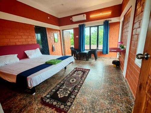 a bedroom with a bed and a table and chairs at Abaca AuroVibe in Kuilapayam