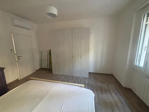 an empty room with a bed and a closet at Appartamento Primavera in Cremona