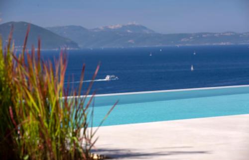 a beach with the ocean and a boat in the water at Cloud Nine Villa in Évyiros