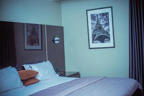 una camera da letto con un letto e un'immagine della torre Eiffel di Xanders Villa a Mama