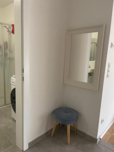 a bathroom with a blue stool and a mirror at Schöne Wohnung in Korneuburg