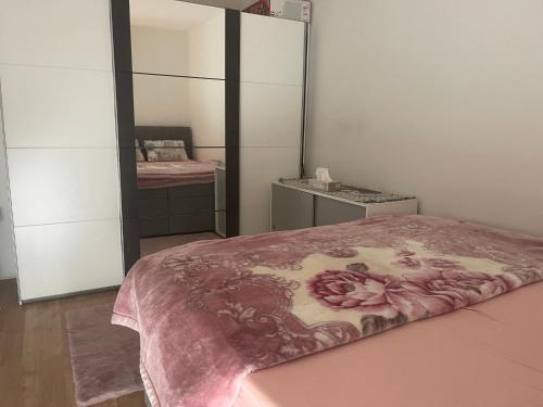 a bedroom with a bed with a pink blanket on it at Schöne Wohnung in Korneuburg