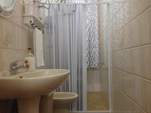 a bathroom with a sink and a shower with a shower curtain at Appartamento Onda Marina in Polignano a Mare