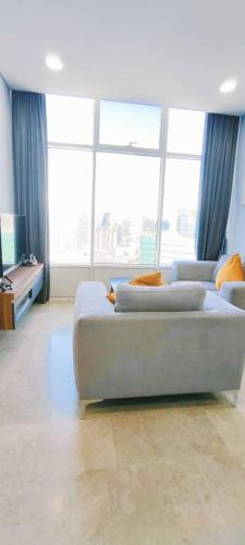 a living room with a couch and a large window at Sky Suites KLCC by TD Luxe Global in Kuala Lumpur