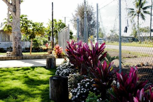 a garden with purple flowers and a fence at Toafa Elidad Airport Lodge 