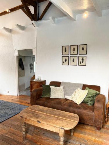 a living room with a couch and a coffee table at Le Petit Verger Gîte in Bonnes