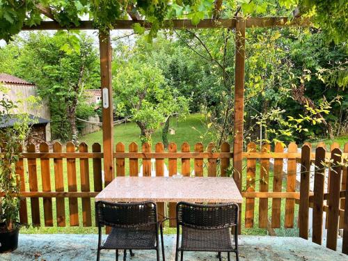 a table and two chairs sitting under a gazebo at Le Petit Verger Gîte in Bonnes