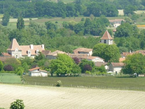 a group of houses on a hill with a field at Le Petit Verger Gîte in Bonnes