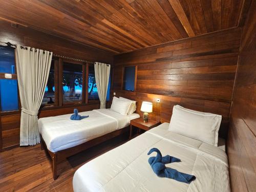 two beds in a room with two blue swans on them at Andau Dive Resort Raja Ampat in Tapokreng