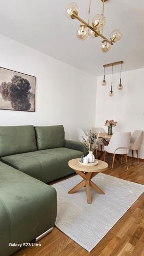 a living room with a green couch and a table at Zlatni TRG in Zlatibor