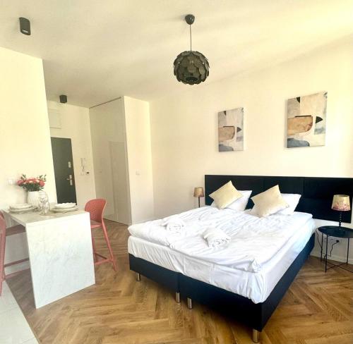a bedroom with a large bed and a table and chairs at Apartamenty Śródmiejska in Świebodzin