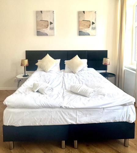 a large bed with white sheets and pillows on it at Apartamenty Śródmiejska in Świebodzin