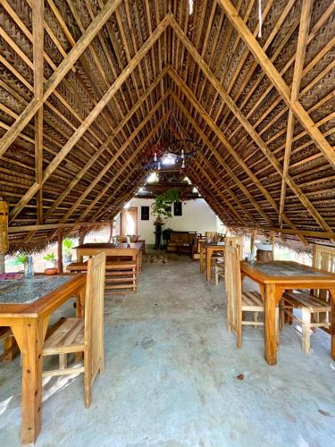a large dining area with wooden tables and benches at Sigiri Birds Hostel in Sigiriya