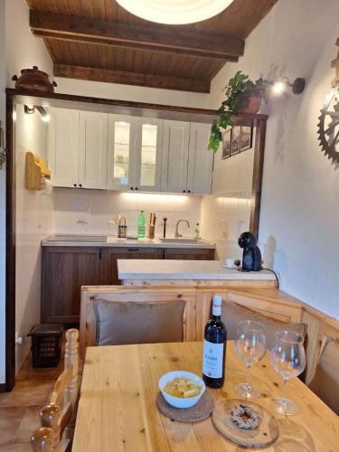 a wooden table with two glasses and a bottle of wine at Appartamento Bellavista in Pievepelago