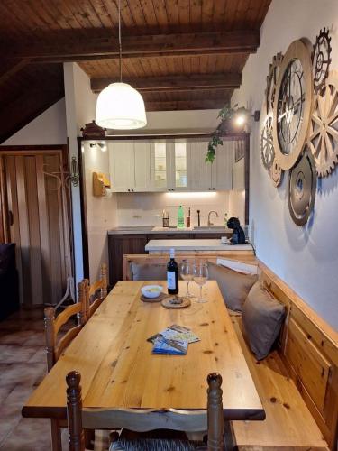 a wooden table in a kitchen with a bottle of wine at Appartamento Bellavista in Pievepelago