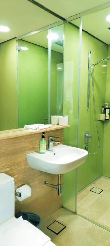 a bathroom with a sink and a shower and a mirror at Sky Suites KLCC by TD Luxe Global in Kuala Lumpur