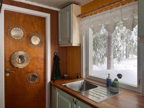 a kitchen with a sink and a window at Charming Cabin At The Foot Of The Mountain in Jordet