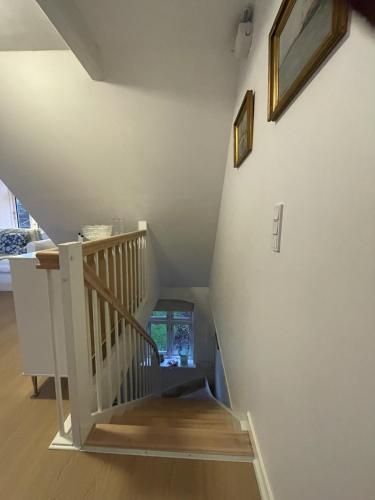 a stairwell with a wooden stair case in a house at Det lille røde hus in Nyord
