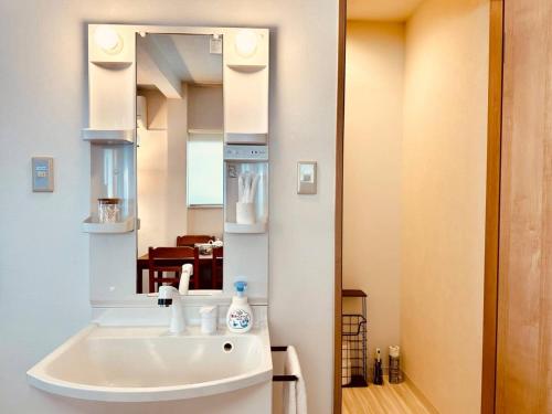 un baño con lavabo y espejo en 456 Mbps 50tv1 4, en Osaka