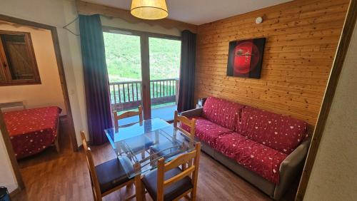 a living room with a red couch and a table at Orelle 3 Vallées - 2 pièces 5-6 personnes in Orelle