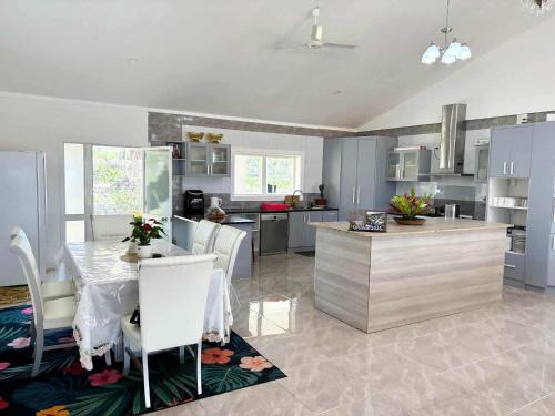a kitchen with a table and a kitchen with blue cabinets at Toafa Elidad Airport Lodge 