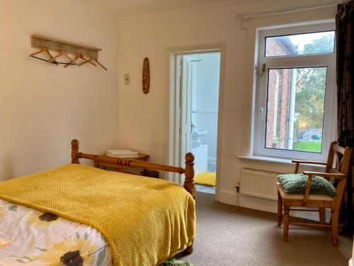 a bedroom with a bed and a window and a chair at “The Reach” Lovely 2 bed house in Gorleston on Sea in Gorleston-on-Sea
