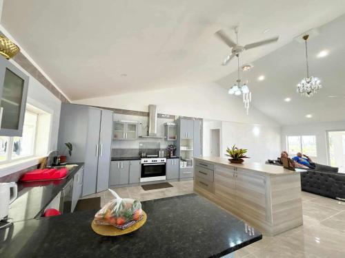 a kitchen with white cabinets and a counter top at Toafa Elidad Airport Lodge 