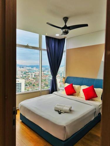 a bedroom with a large bed with red pillows and a window at Sky Suites KLCC by TD Luxe Global in Kuala Lumpur