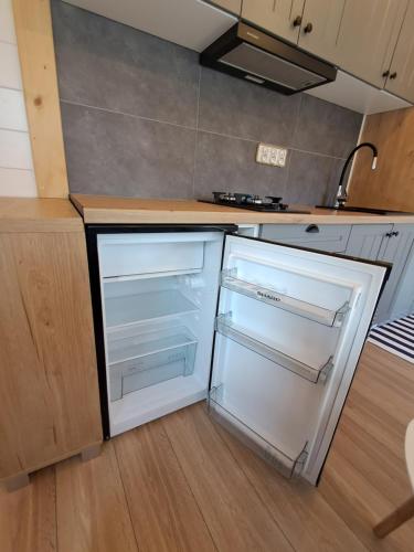 a kitchen with an empty refrigerator in a kitchen at Mazurska Latarnia z prywatną plażą i stawem in Rydzówka
