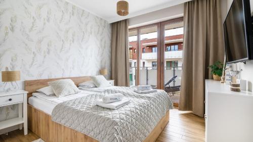 a bedroom with a bed and a large window at STEGNA PARK B Apartamenty PIAMOLA in Stegna