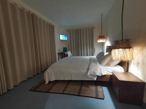 a bedroom with a white bed and a couch at Resort Açude 