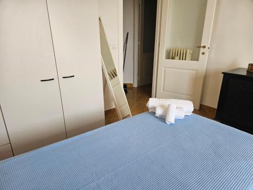 a bedroom with a bed with a stack of towels on it at La Casa di Iole a San Lorenzo, trilocale in via Pietrabruna vicino alle spiagge in San Lorenzo al Mare