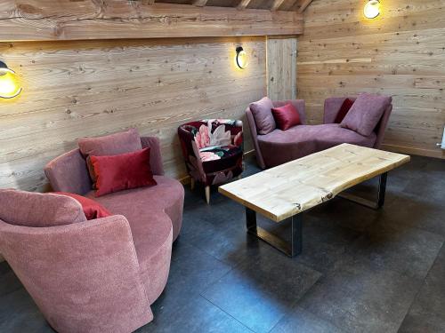 a room with couches and a table and chairs at Maison Cœur Clarée in Névache