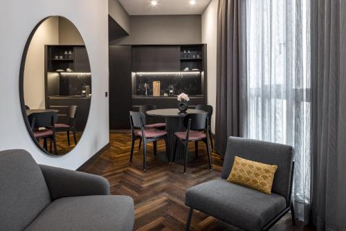 a living room with a table and chairs and a mirror at AMANO Home Leipzig in Leipzig