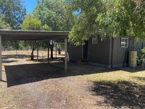 a small green building with a canopy in a yard at Cycle on Star Lane in Wooragee