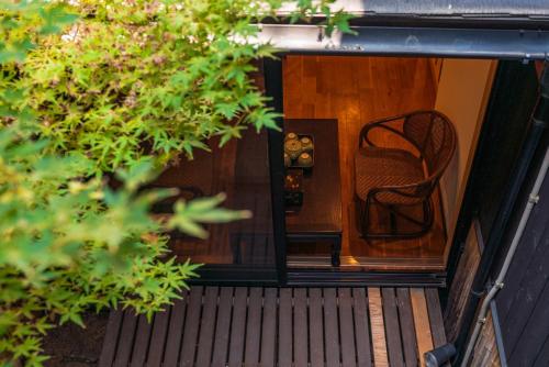 a wooden door with a chair on a porch at Shirakabanoyado - MUTSUKI, Japanese House with Garden & 3 Bathrooms, 白樺の宿 睦月 in Osaka