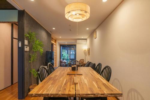 a dining room with a wooden table and chairs at Shirakabanoyado - MUTSUKI, Japanese House with Garden & 3 Bathrooms, 白樺の宿 睦月 in Osaka